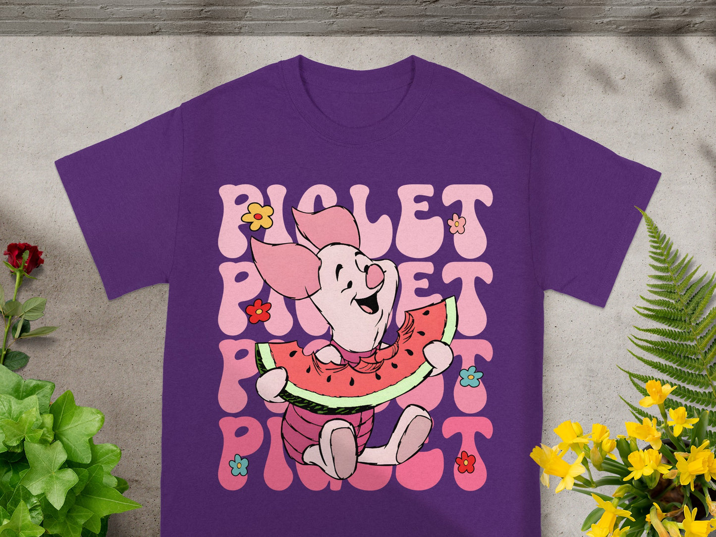 Piglet on purple t-shirt eating watermelon with flowers and text "Piglet".