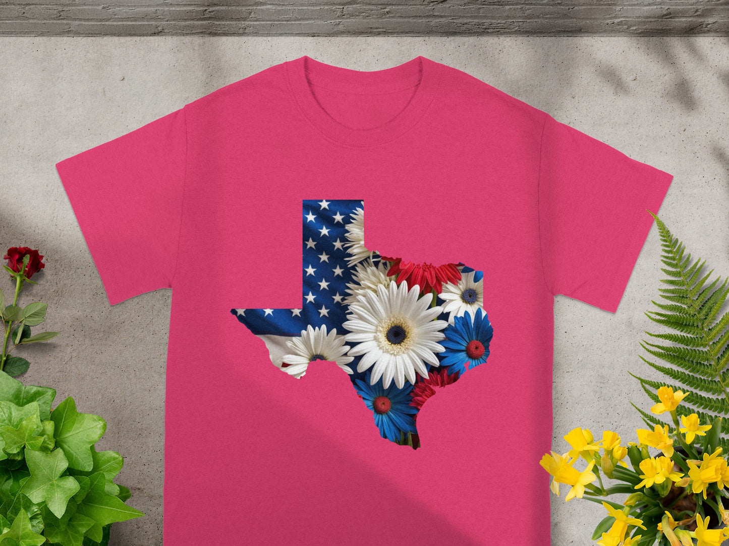 Pink t-shirt featuring a Texas outline filled with American flag and flowers.