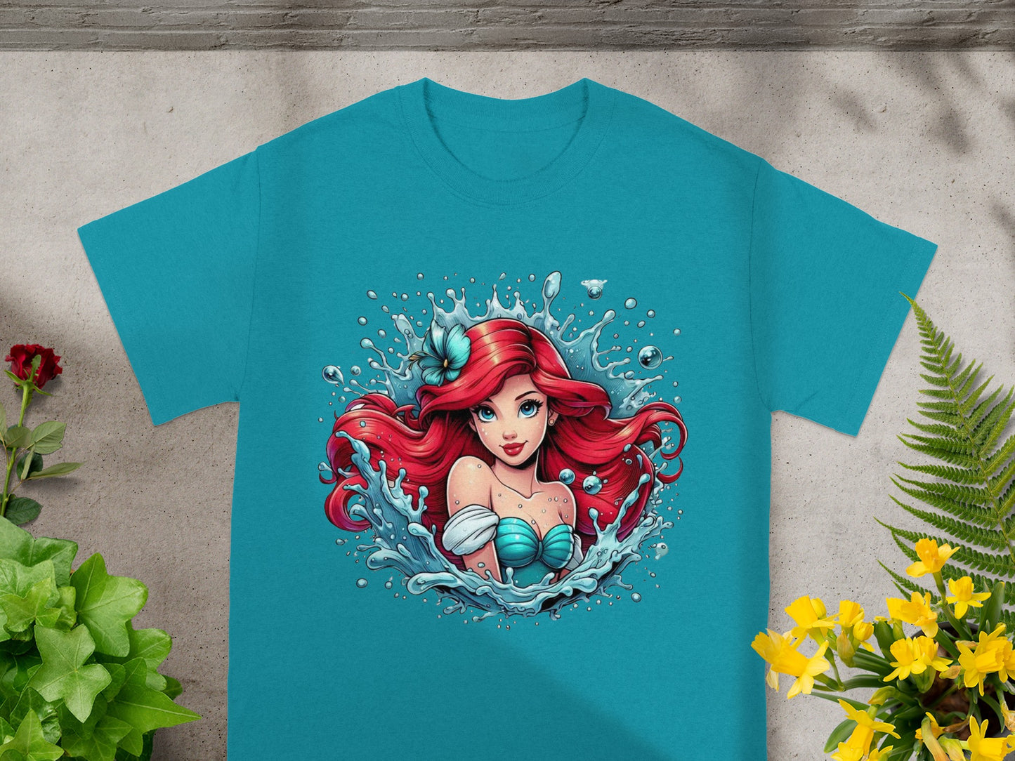 Ariel from The Little Mermaid in a splash of water on a teal t-shirt.