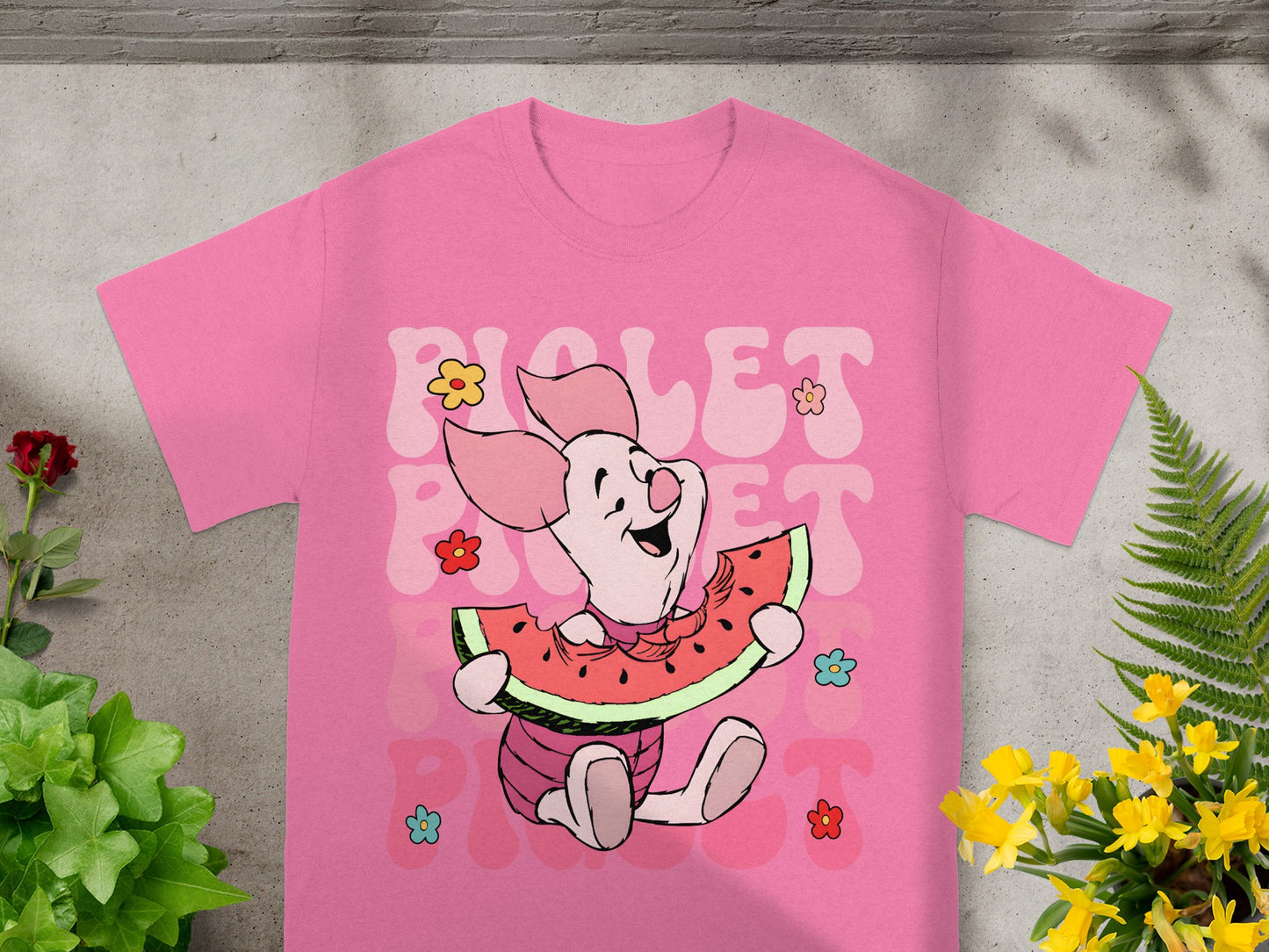 Pink t-shirt with Piglet character eating watermelon and colorful flowers.