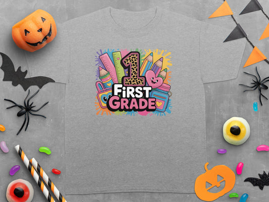 Gray t-shirt with "1st GRADE" graphic featuring school supplies and a heart.