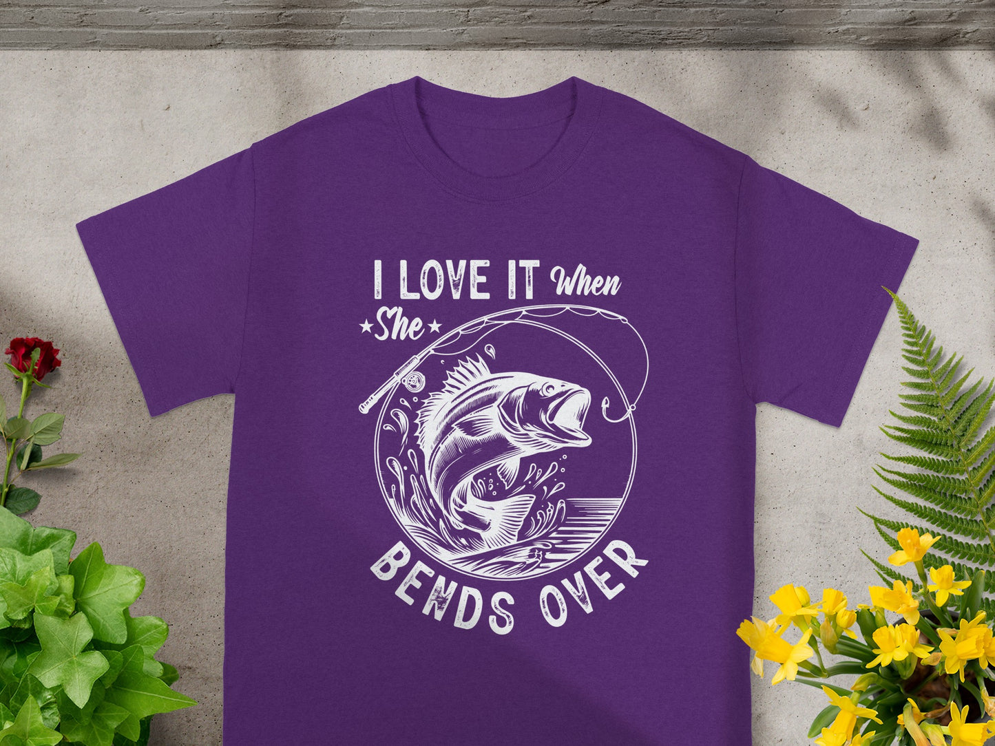 Purple t-shirt with graphic of jumping fish and text "I LOVE IT When She BENDS OVER".