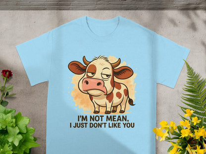 Light blue t-shirt with a grumpy cow illustration and text reading "I'm not mean, I just don't like you."
