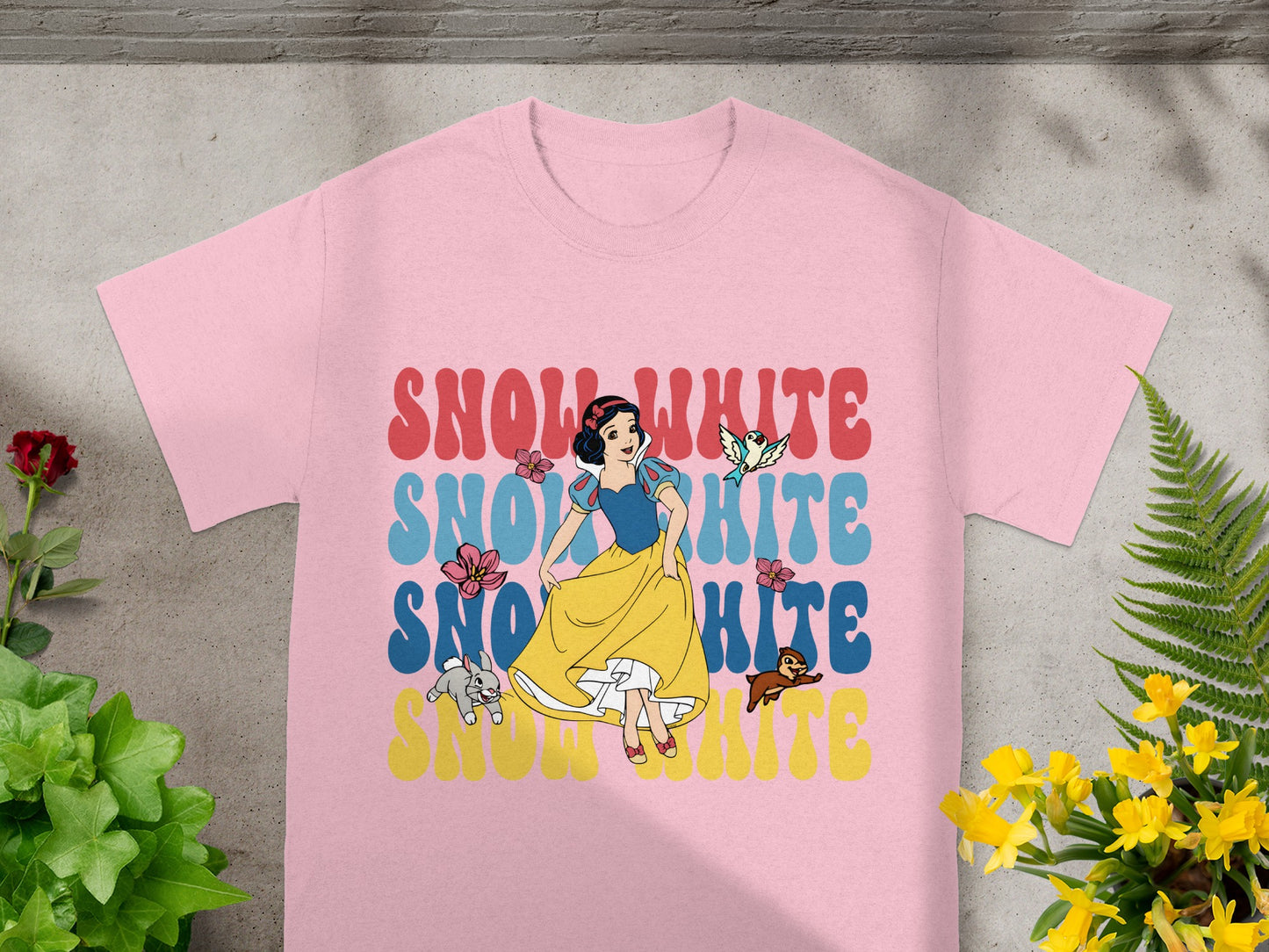 Snow White graphic on a pink t-shirt with colorful text.