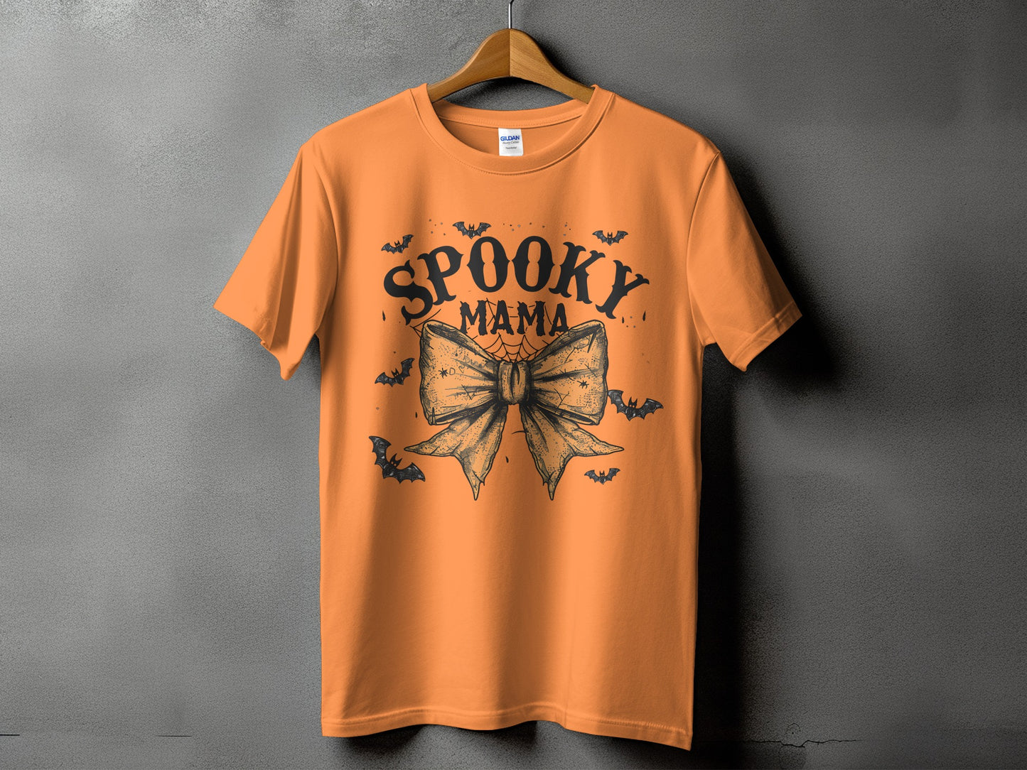 Orange t-shirt with "Spooky Mama" text and a large bow with bats.