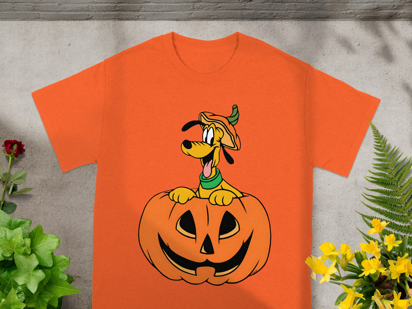 Orange t-shirt featuring Pluto peeking out of a Jack-o'-lantern.