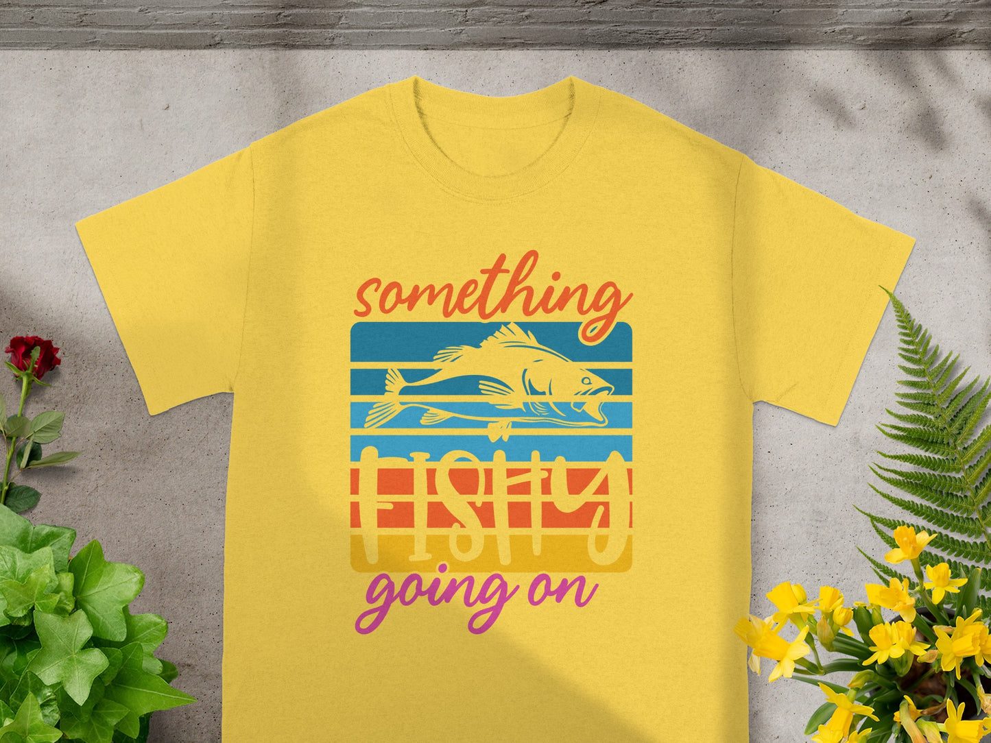 Yellow t-shirt with "something fishy going on" text and fish graphic.
