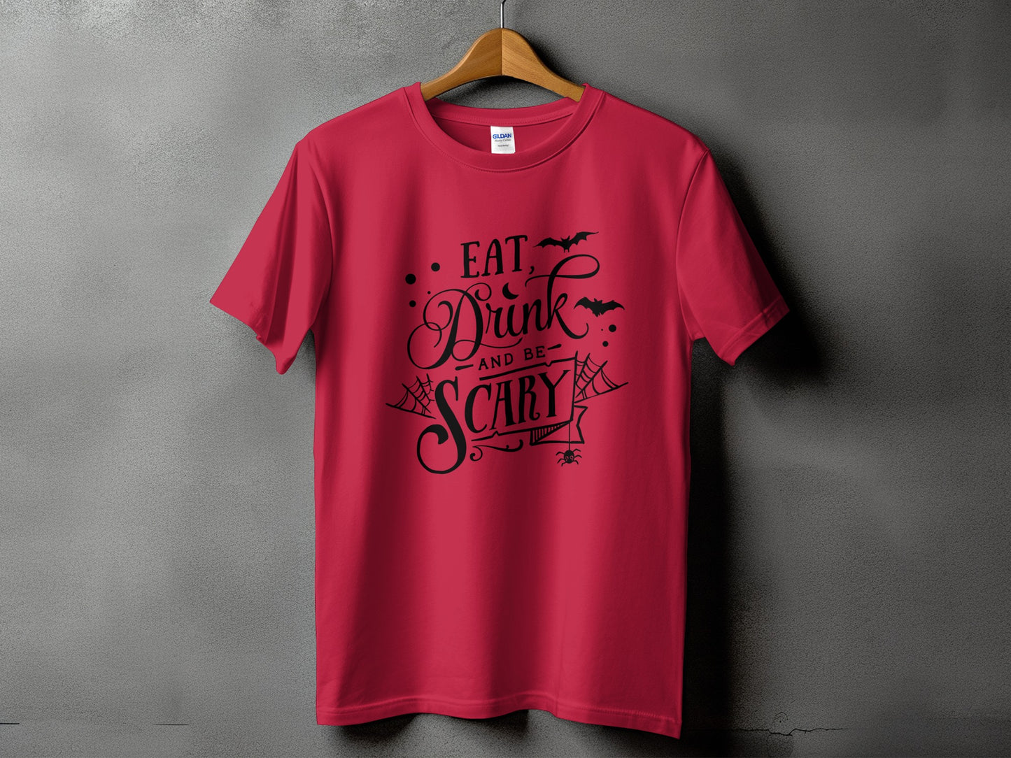 Red t-shirt with black text reading "Eat, Drink, and Be Scary" for Halloween.