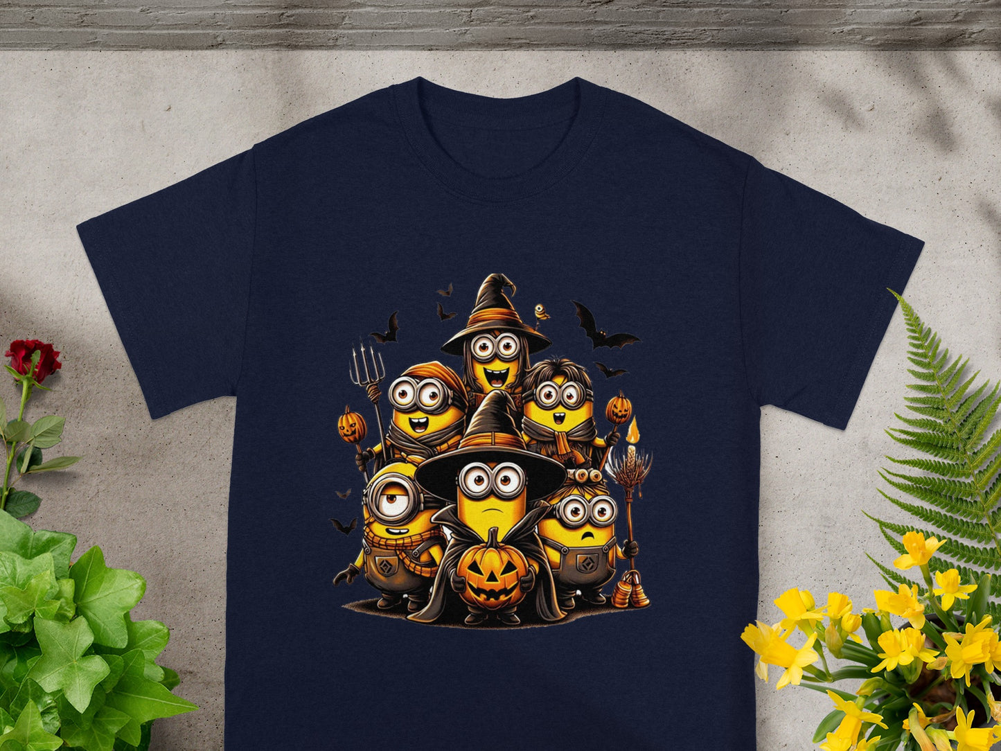 Minions in Halloween costumes with pumpkins and bats on a navy t-shirt.