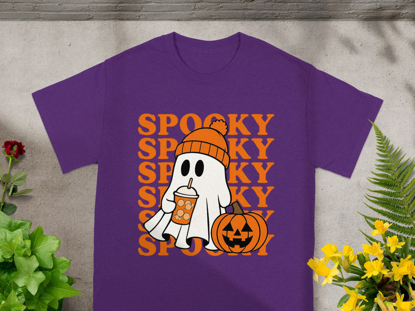 Purple t-shirt with cartoon ghost holding drink and pumpkin, "SPOOKY" text.