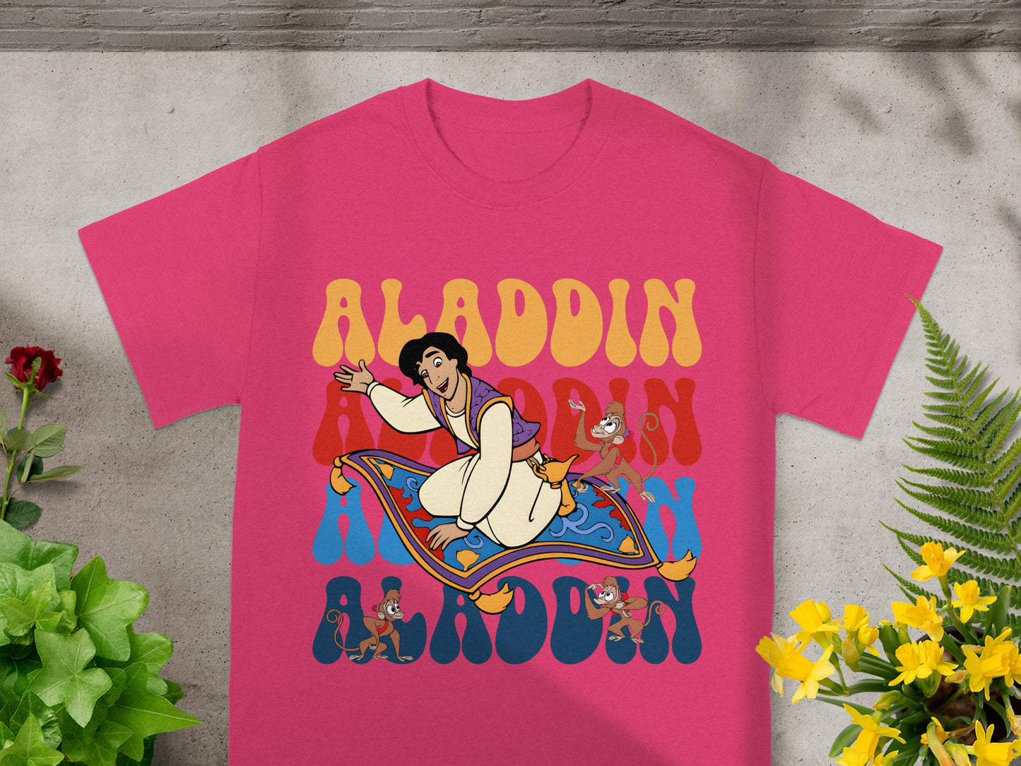 Aladdin rides a magic carpet with monkeys, text reads Aladdin.