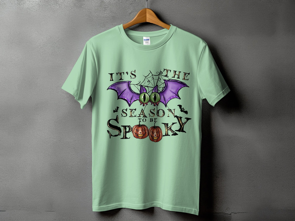 Light green t-shirt with "It's The Season To Be Spooky" Halloween graphic.