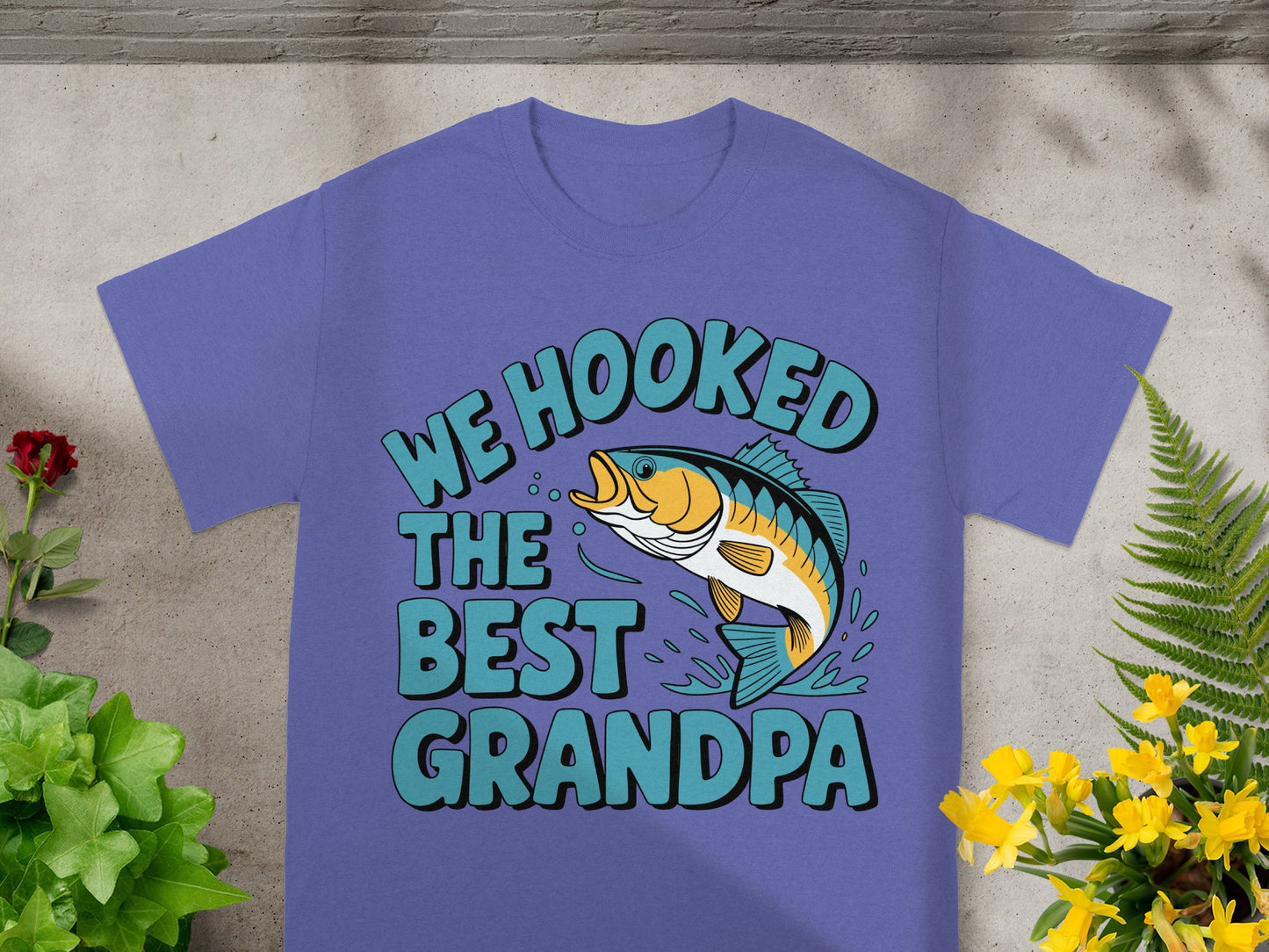 Purple t-shirt with text "WE HOOKED THE BEST GRANDPA" and a jumping fish graphic.