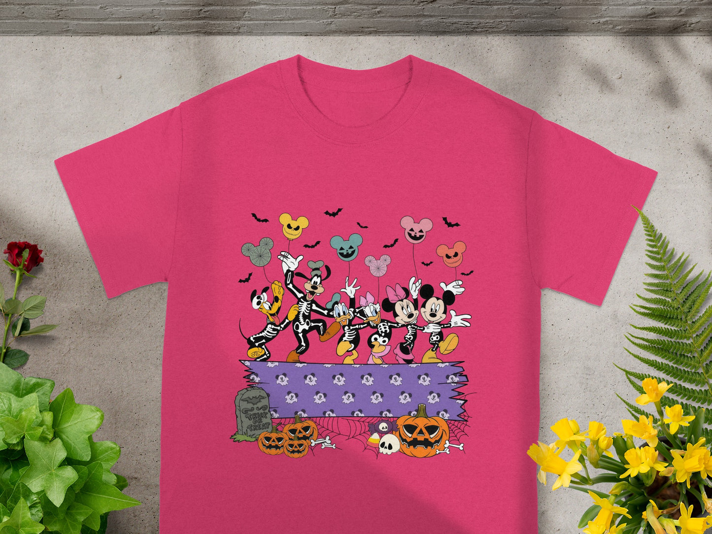 Mickey and friends skeleton costumes with Halloween pumpkins and tombstone graphic on pink t-shirt.