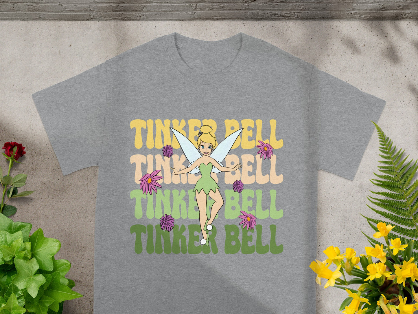 Tinker Bell graphic on a grey t-shirt with floral background.
