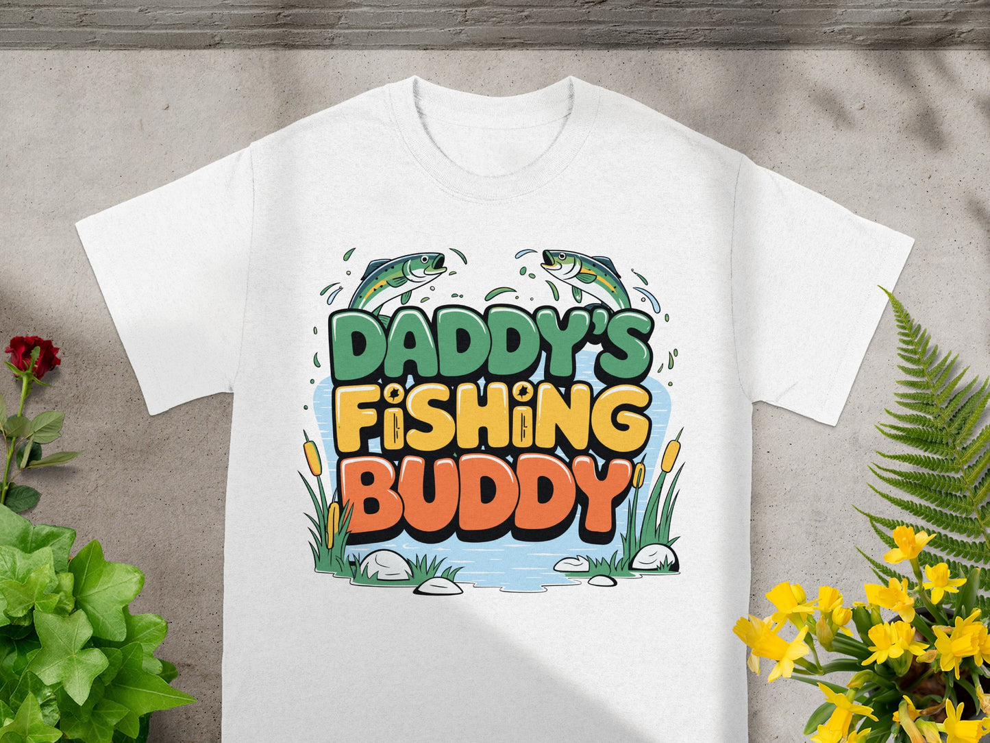 White t-shirt with "Daddy's Fishing Buddy" text, cartoon fish, and cattails.