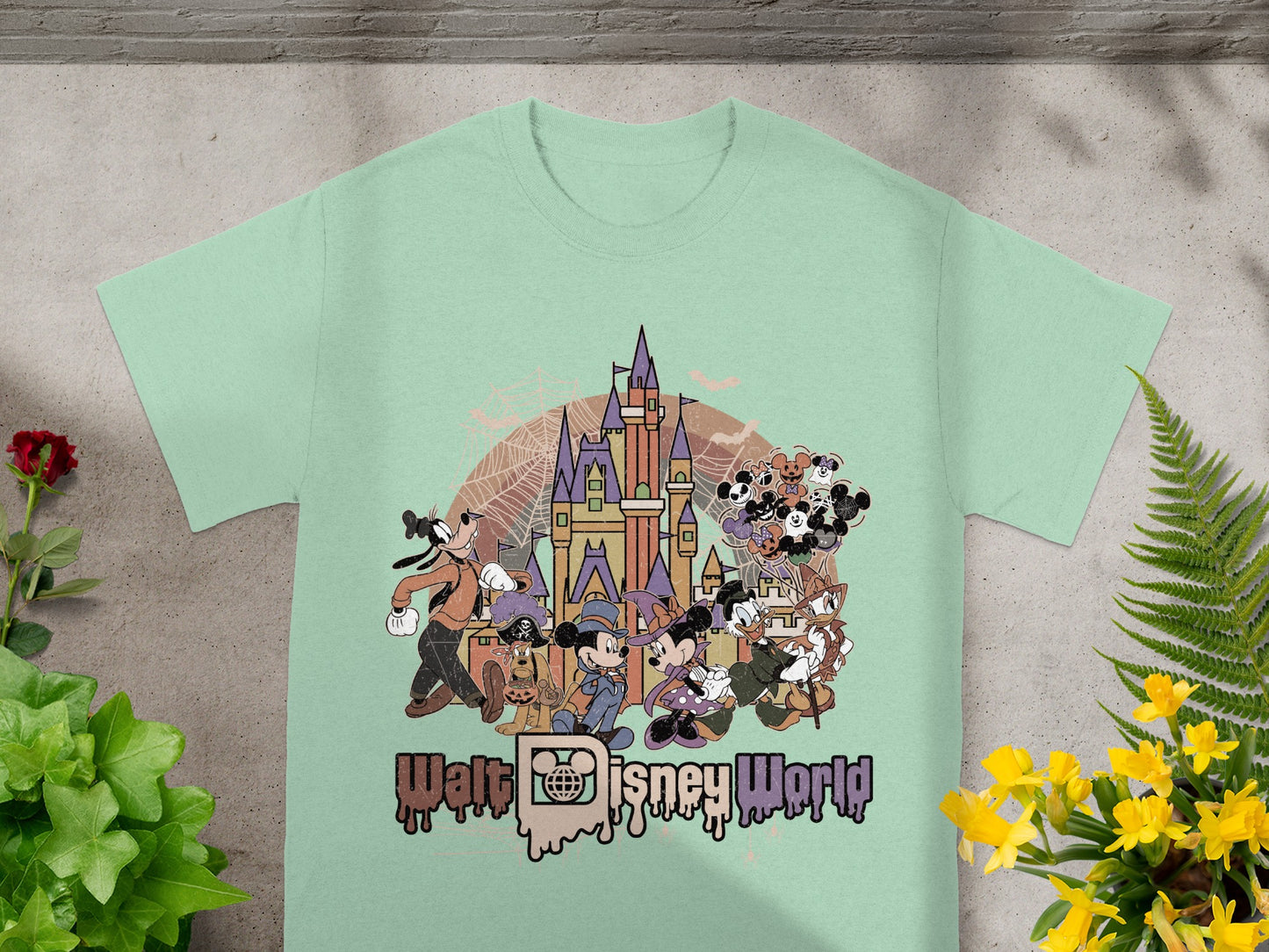 Walt Disney World graphic with characters and Cinderella Castle on a mint green t-shirt.