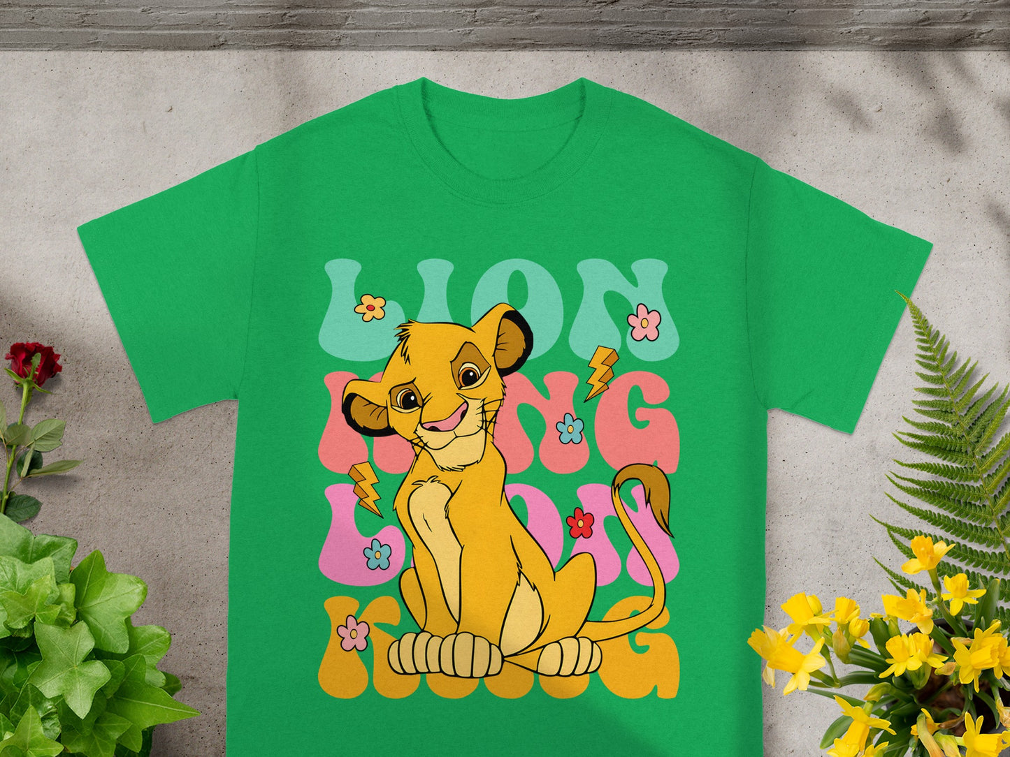 Simba from The Lion King on a green t-shirt with colorful text.