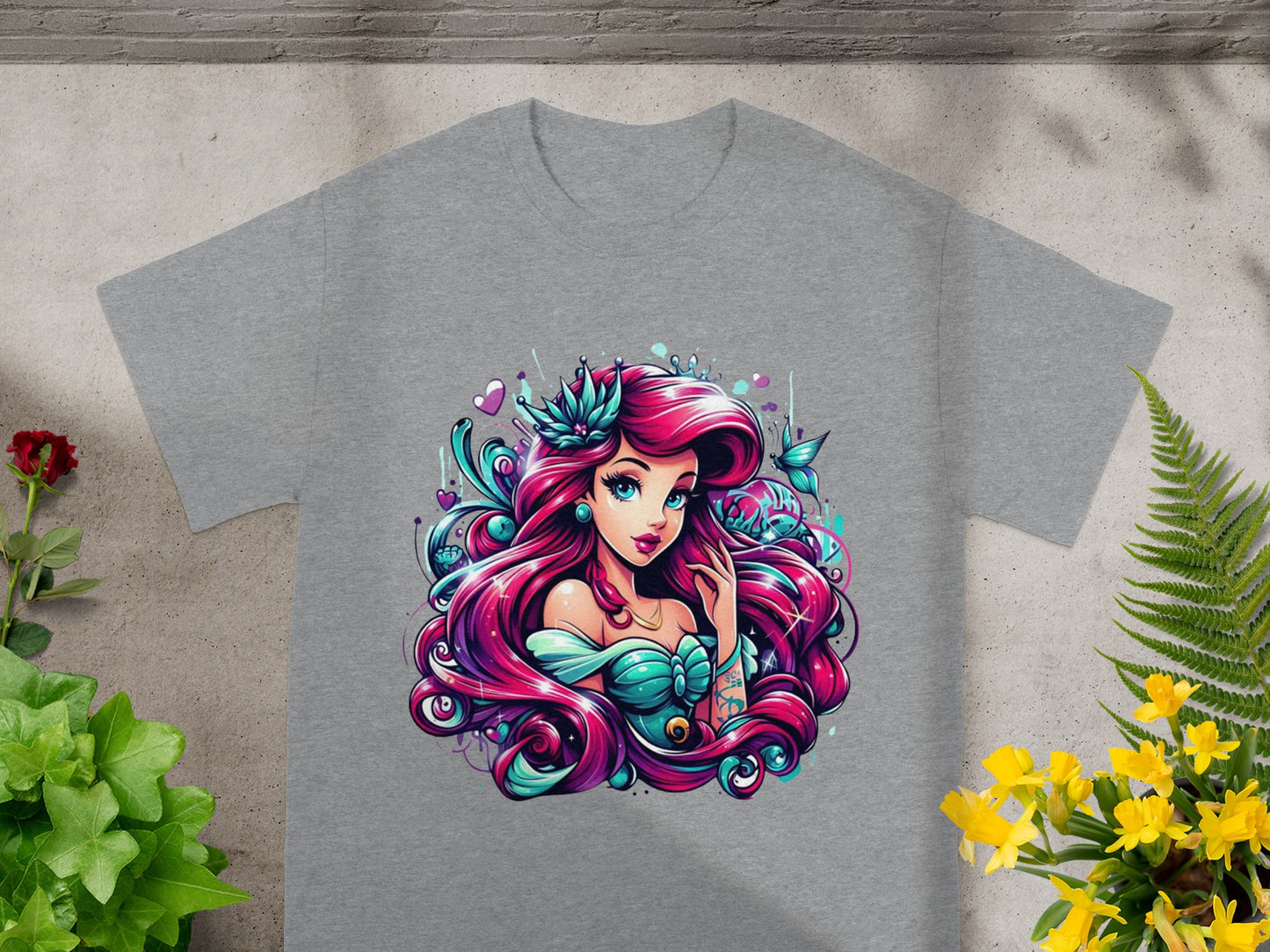T-shirt featuring a cartoon mermaid with pink hair and teal tail.