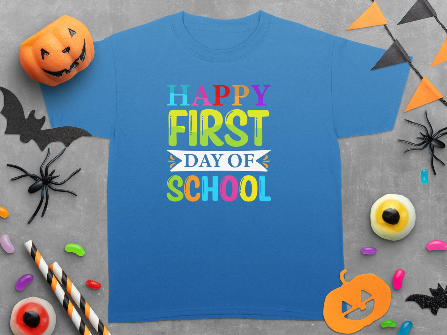 Blue t-shirt with "Happy First Day Of School" text in colorful block letters.